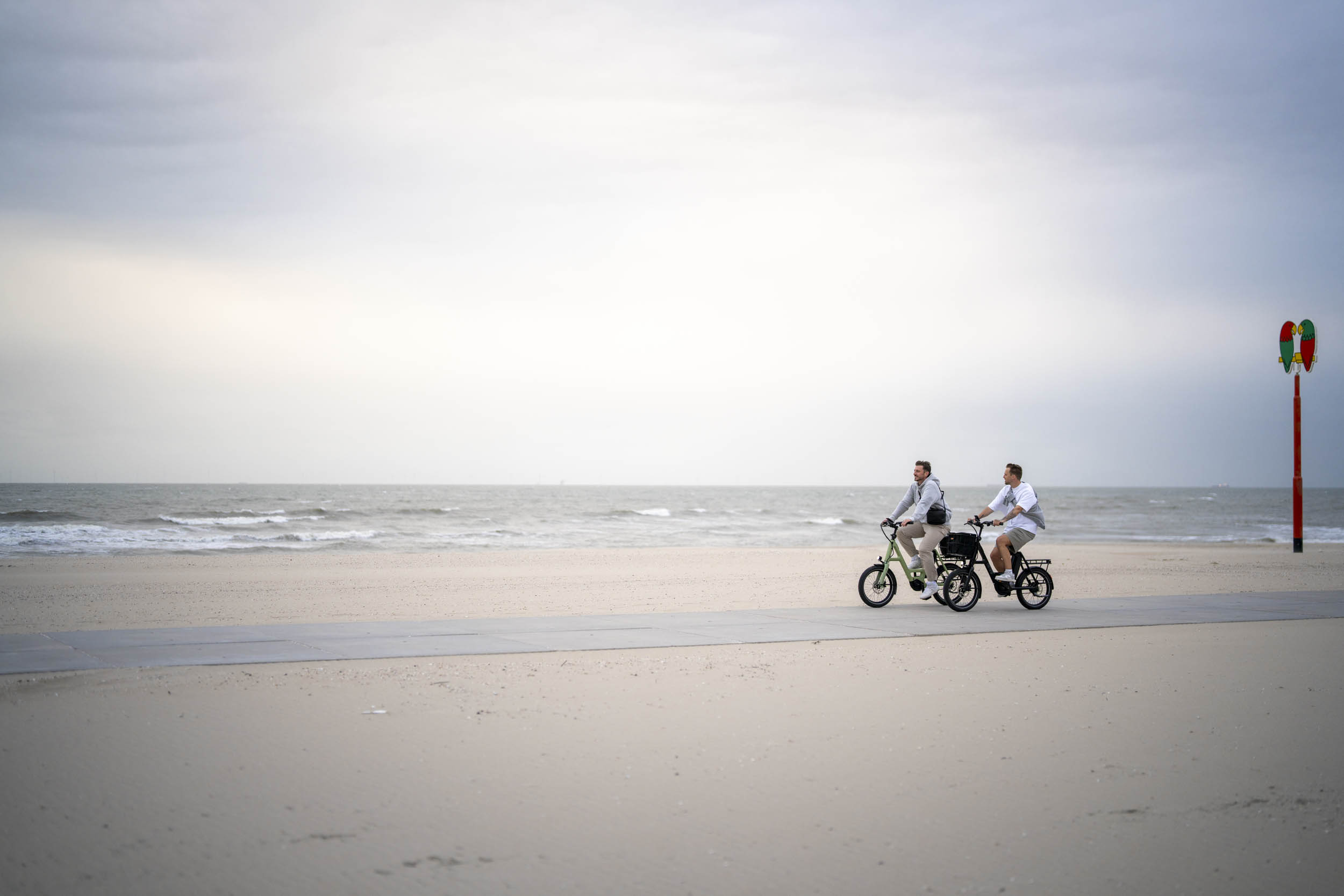 Zwei Männer auf i:SY E-Bikes am Strand